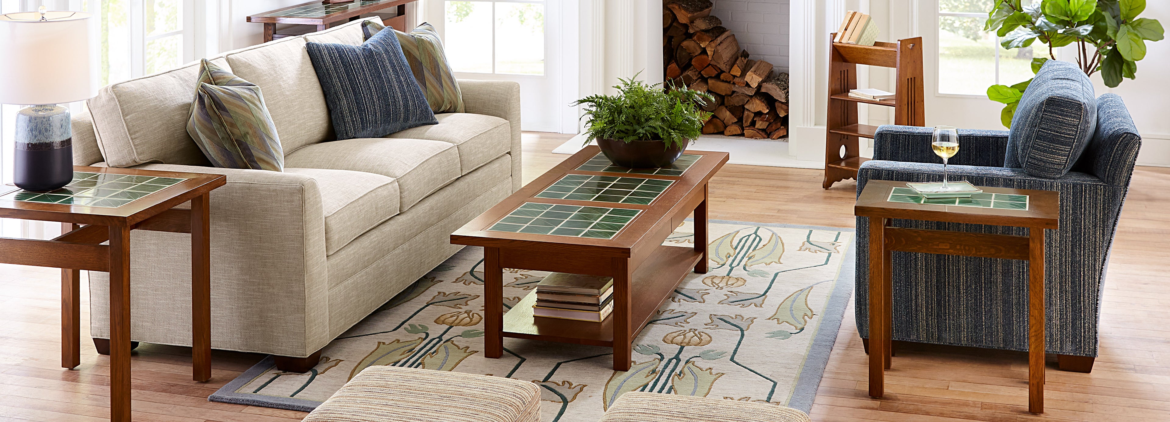 Stickley living room setup featuring cream colored couch, blue print arm chair, and Mission tile-top tables